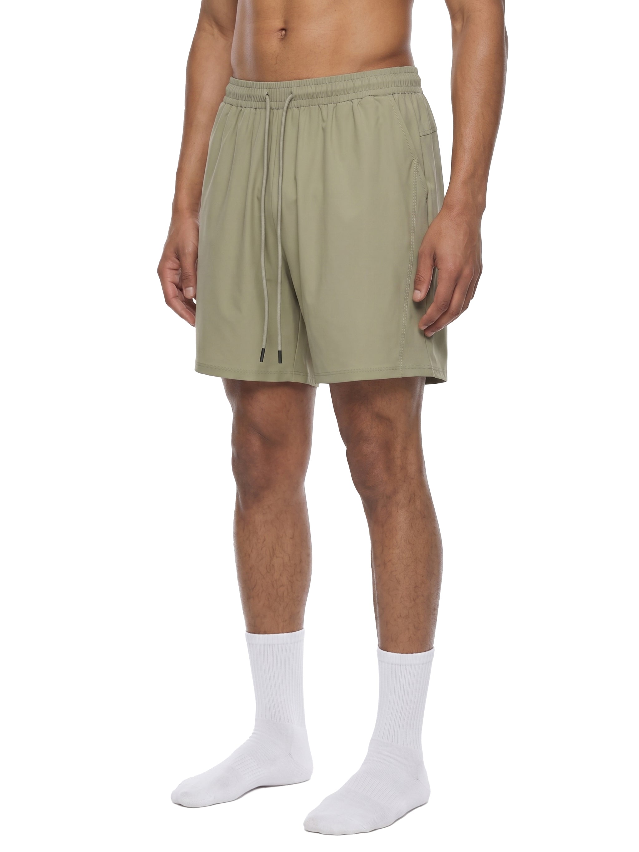 Person wearing olive green shorts on a white background